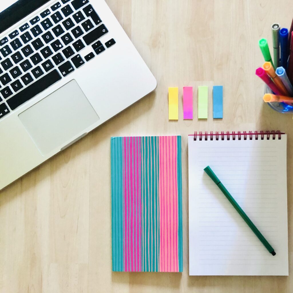 Arbeitsplatz mit Laptop, Notizblock und Stiften