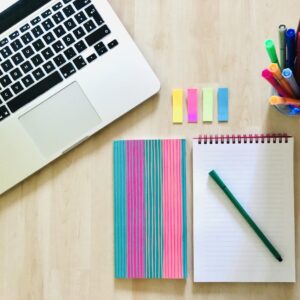Arbeitsplatz mit Laptop, Notizblock und Stiften